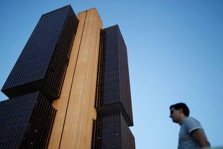FILE PHOTO: A man stands near the headquarters of the central bank in Brasilia