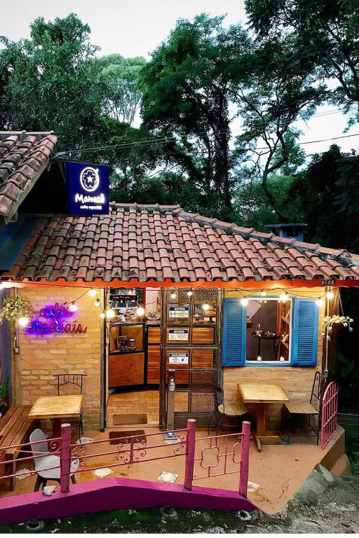 Ambiente externo do Café Manacá, que tem janelas azuis