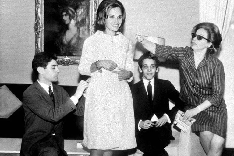 A primeira-dama Maria Thereza Goulart, mulher do presidente João Goulart, veste um modelo do estilista Dener [sentado, atrás] em fotografia dos anos 1960