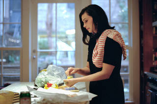 The actress Morena Baccarin fixes moqueca, a Brazilian fish stew, for her three children, at her home in New York, Feb. 4, 2022. (Shina Peng/The New York Times)