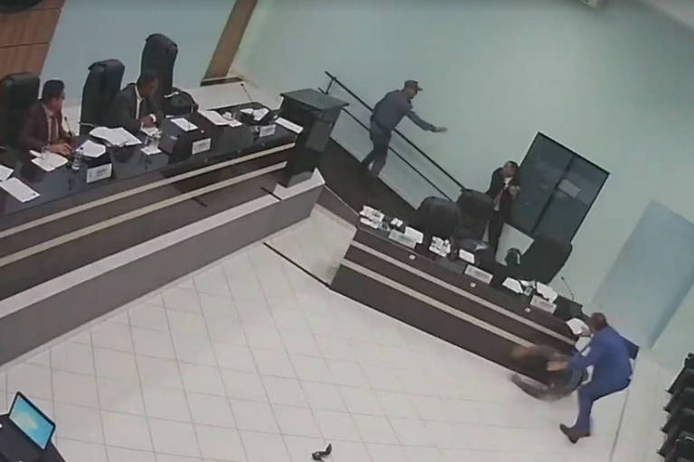 A imagem mostra o vereador apontando um revólver para o colega durante sessão da câmara de Querência (MT).