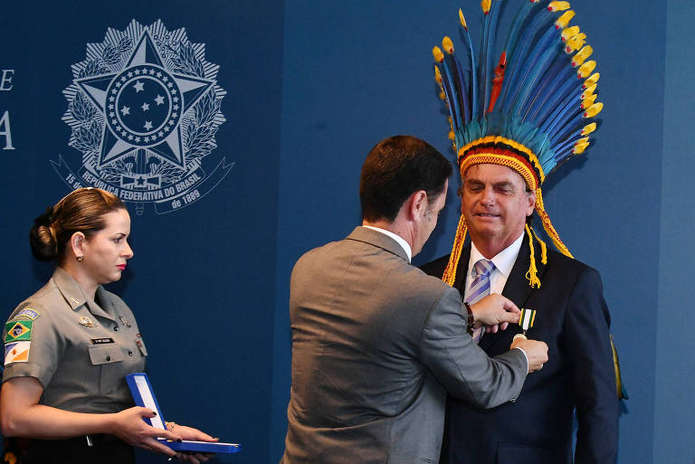 O presidente Jair Bolsonaro recebe a Medalha do Mérito Indigenista, embora ele tenha afirmado que não haveria um centímetro de demarcação de terras indígenas em seu governo
