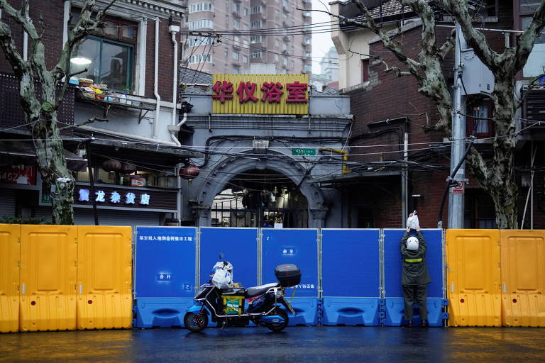 Morador de região isolada em Xangai recebe entrega em meio ao lockdown parcial na cidade chinesa