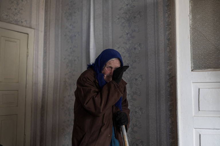 Idosa observa situação de sua casa após ataques; veja fotos da guerra na Ucrânia