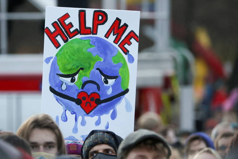 Manifestantes carregam cartaz em protesto durante a COP26, a Conferência das Nações Unidas sobre Mudança do Clima de 2021, em Glasgow, na Escócia