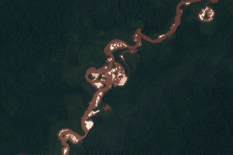 Foto aérea mostra rio cortando uma área de mata com pontos mais claros marcados em sua água, como consequência do garimpo