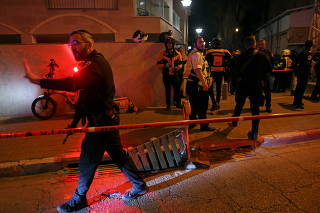 Israeli security and medical personnel secure the scene of an attack in which people were killed by a gunman on a main street in Bnei Brak, near Tel Aviv