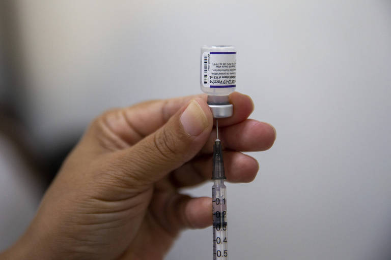 Enfermeira da UBS localizada na Vila Madalena segura frasco da vacina contra a Covid-19 da Pfizer-BioNTech. Vacinação de idosos para a quarta dose da vacina contra a Covid, em São Paulo
