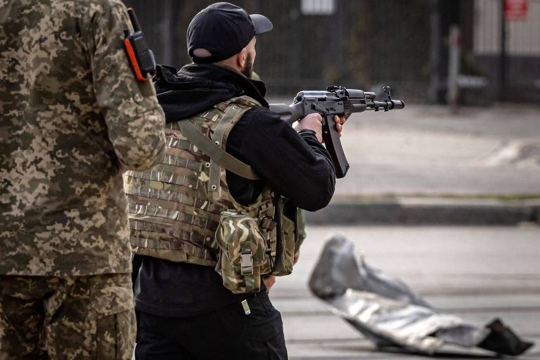Militar ucraniano aponta seu rifle na cidade de Kharkiv