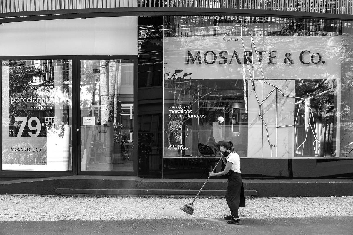 Funcionária varre calçada de loja na rua Gabriel Monteiro da Silva, no Jardim Europa, área de comércio de alto padrão, em São Paulo. Em 29.abr.2020