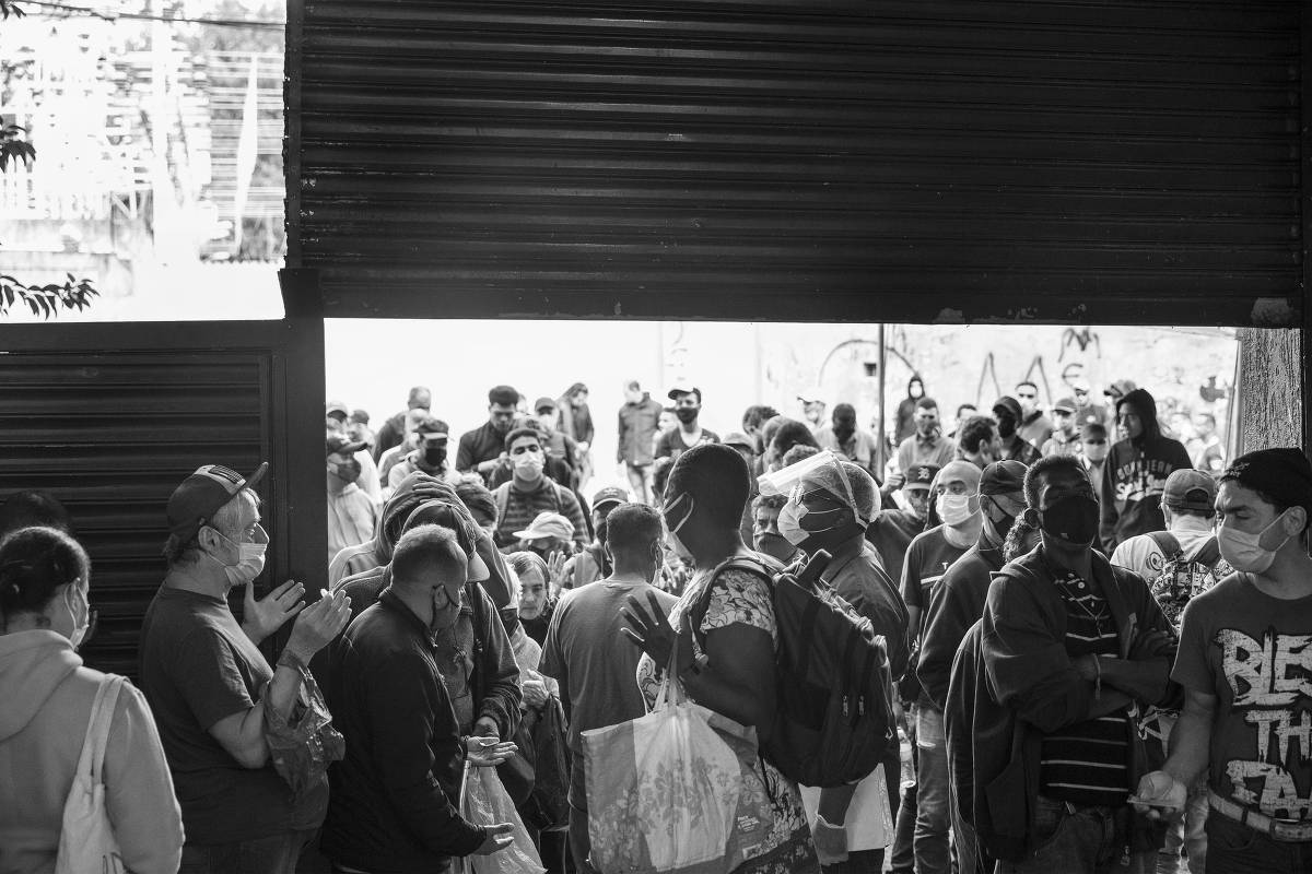 Moradores em situação de rua fazem fila para conseguir alimentação no Centro Comunitário São Martinho de Lima, no bairro do Belém, zona leste de São Paulo, em projeto coordenado pelo padre Júlio Lancellotti, em 10.mai.2021 