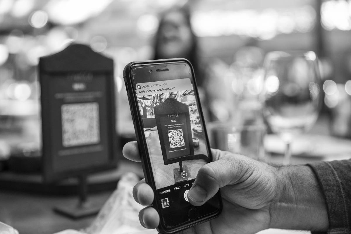 Clientes usam celular para ler QR Code e ter acesso ao menu do restaurante Figueira Rubaiyat, nos Jardins, em 10.jul.2020 
