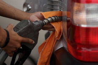 FILE PHOTO: A gas station worker fills a car's tank in Leme Beach in Rio de Janeiro
