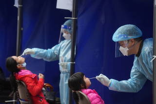 FILE PHOTO: Medical workers take swab samples from residents at a community nucleic acid testing centre for the coronavirus disease (COVID-19) at Sha Tin district, in Hong Kong