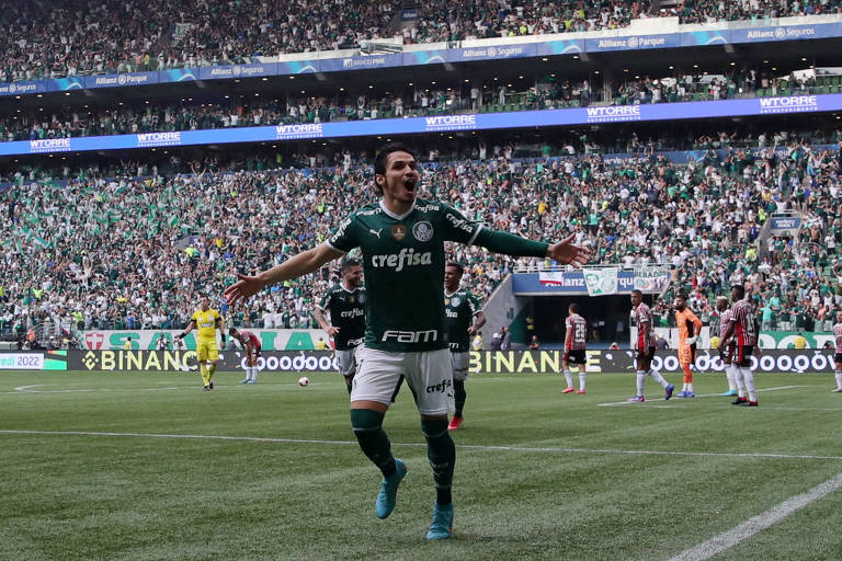 Homem de braços abertos em campo celebrando