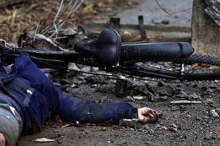 A body of a woman, who according to residents was killed by Russian army soldiers, lies on the street, amid Russia invasion on Ukraine in Bucha