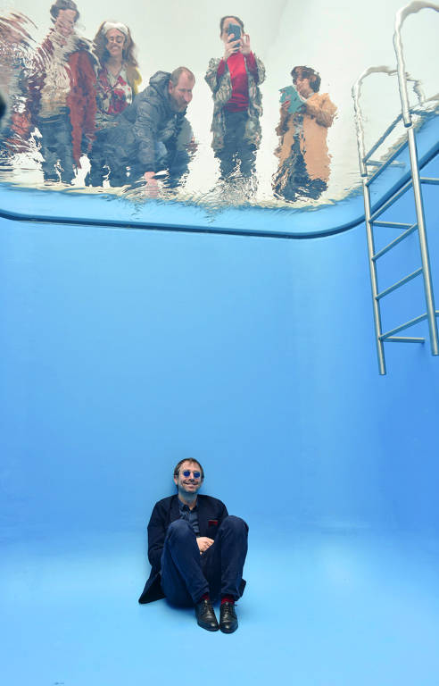 Leandro Erlich, o artista por trás das obras expostas em 'A Tensão', sentado no fundo da obra 'Swimming Pool', exposta em Buenos Aires em 2019