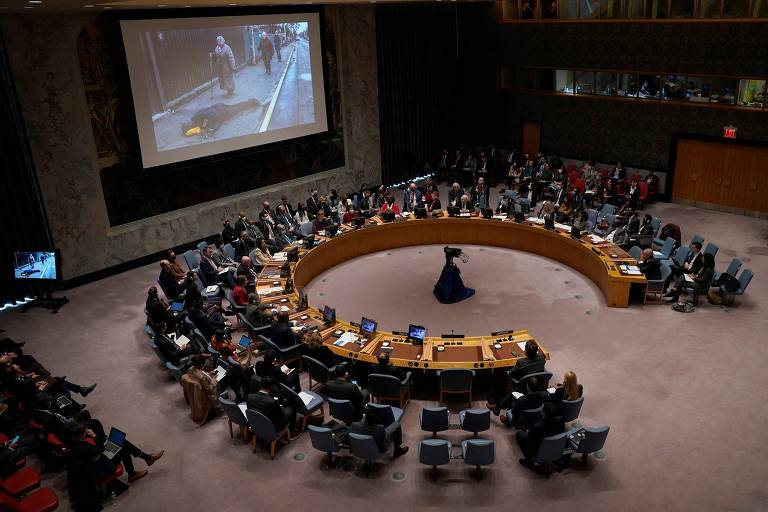 Imagens de civis mortos na rua são exibidas no telão do Conselho de Segurança da ONU, em Nova York