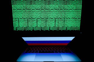 FILE PHOTO: Russian flag is seen on the laptop screen in front of a computer screen on which cyber code is displayed, in this illustration picture