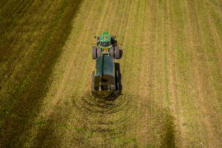 A custom hauler spreads dairy manure on hay ground in Wallenstein, Ontario