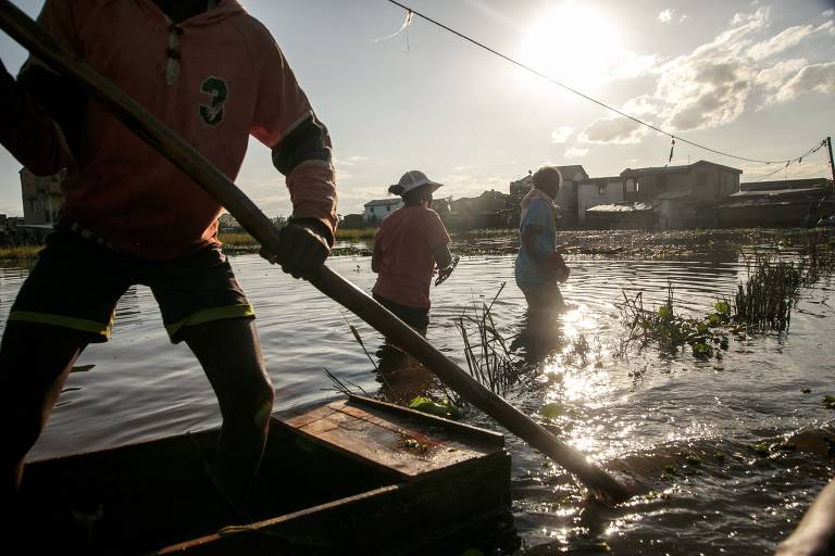 Moradores do bairro de Ankasina usam barcos para chegarem às suas casas em Antananarivo, capital de Madagascar, um dos países que têm sofrido com as tempestades tropicais neste início de ano, como Moçambique e Malawi