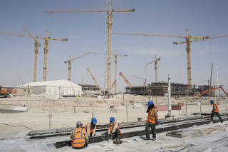 Workers build the tramway rails in front of the Lusail Stadium, where the final of the World Cup 2022 will take place, in the planned city of Lusail, Qatar.