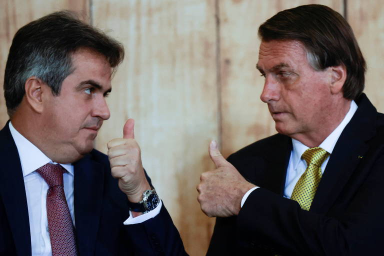 Ciro Nogueira e Jair Bolsonaro, ambos de terno e gravata, fazem sinal de positivo um para o outro com os polegares