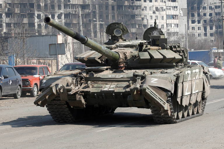 Tanque russo passa por prédios queimados na cidade de Mariupol