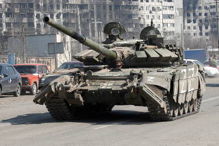 FILE PHOTO: A tank of pro-Russian troops drives in a street in Mariupol