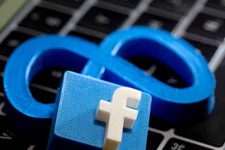 3D-printed images of the logos of Facebook and parent company Meta Platforms are seen on a laptop keyboard in this illustration