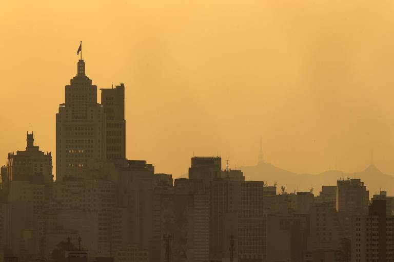 Vista do centro da cidade de São Paulo, com o Farol Santander à frente e o pico do Jaraguá ao fundo, quase imperceptível devido à densa camada de poluição na atmosfera