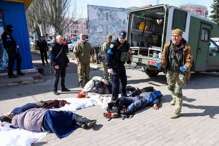 Militares e equipes de emergência ucranianas ao lado de vítimas  de ataque a uma estação de trem em Kramatorsk, na região do Donbass