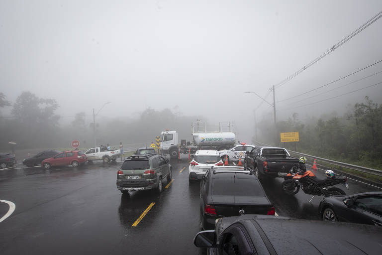 Fila de carros em rodovia coberta de neblina