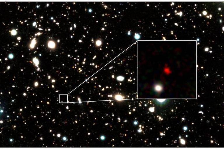 Imagem destaca a galáxia mais distante já vista, HD1, cuja luz viajou 13,5 bilhões de anos antes de chegar até nós.
