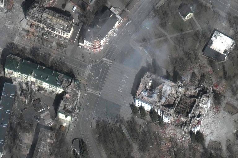 Imagem de satélite mostra destruição do teatro de Mariupol e dos prédios vizinhos; em frente à construção havia a palavra 'crianças' pintada em letras grandes com tinta branca