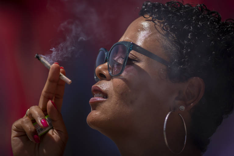 Viviane Silveira, 35, ou MC Vivi Boop, fuma um cigarro enrolado com as flores de Cannabis sativa que usa na Alemanha, onde vive, para tratamento de fibromialgia. Ela obteve autorização da Justiça Federal brasileira para entrar no país com 300 g da planta, proibida no país