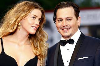 FILE PHOTO: Actor Johnny Depp and his wife Amber Heard attend the red carpet event for the movie 