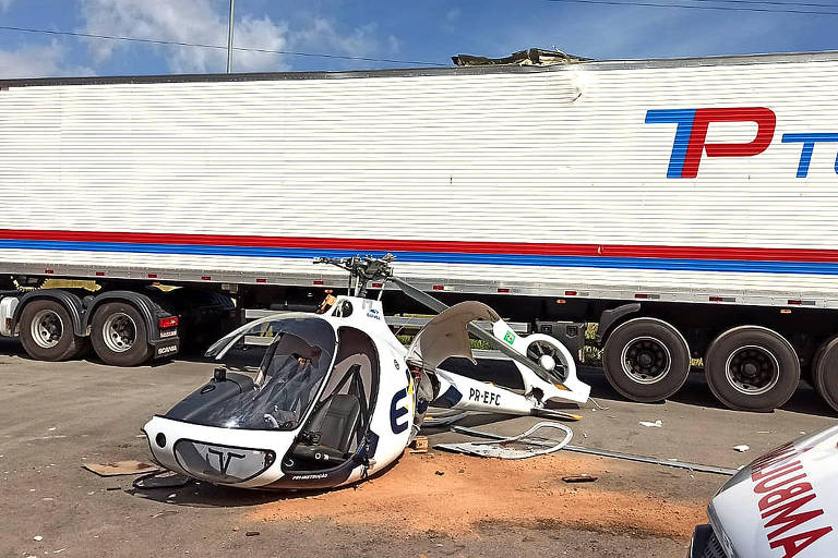 A foto mostra um helicóptero branco que caiu em área aparentemente privada de estacionamento de caminhões em Contagem, na Grande Belo Horizonte.