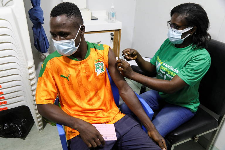 Torcedor da Costa do Marfim é vacinado antes da partida entre sua seleção e Guiné Equatorial, pela Copa das Nações Africanas, em Abidjan, Costa do Marfim