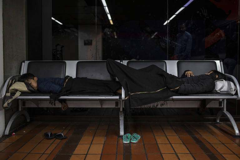 Os filhos mais novos do casal dormem em um banco do aeroporto