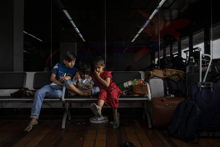 Os filhos de Mohammad e Khalida assistem a vídeos com desenhos no celular do casal