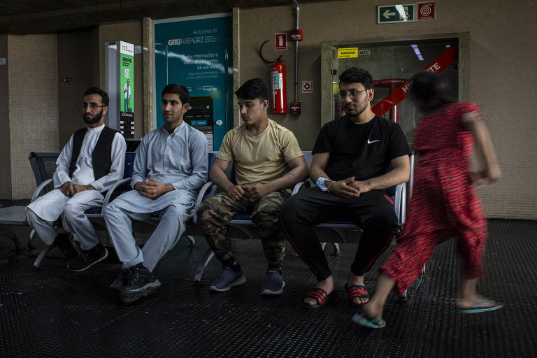 Da esq. para a dir., Hekmat Ulah, Akram Kamawl, Ahmad Shinwari e
Ghlam Nabi Sidiqi conversam enquanto Sofia corre em um raro momento de brincadeira