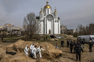 Bodies are exhumed from a communal grave near the Church of St. Andrew in Bucha, Ukraine, April 8, 2022.  (Daniel Berehulak/The New York Times)