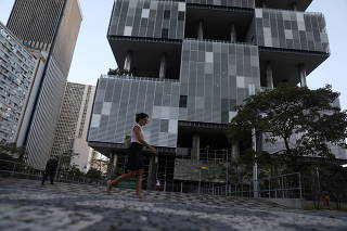 A woman walks past the headquarters building of Brazilian oil company Petrobras in Rio de Janeiro