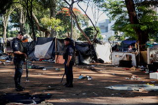 Metropolitan civil guards stand during an operation to remove trash and tents used by homeless people and drug users in an area known as 