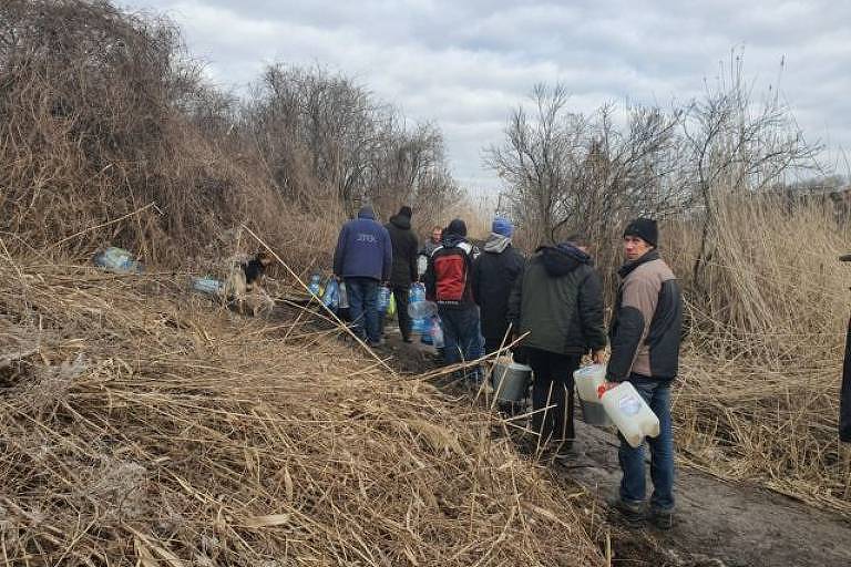 Ucranianos formam fila para buscar água em rio