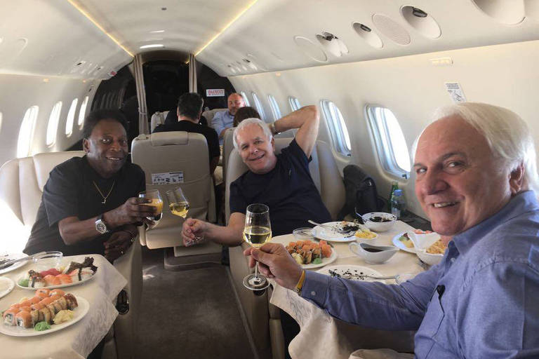 Três homens em um avião brindado