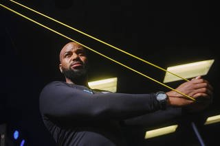 Gerard Burley, or Coach G, uses exercise bands during a workout at DC Sweat in Washington, March 30, 2022. (Jared Soares/The New York Times)