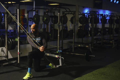 Gerard Burley, or Coach G, stretches his exercise bands for more resistance during a workout at Sweat DC in Washington, March 30, 2022. It?s possible to get a full-body workout with an inexpensive set of elastic resistance bands. (Jared Soares/The New York Times) ORG XMIT: XNYT90