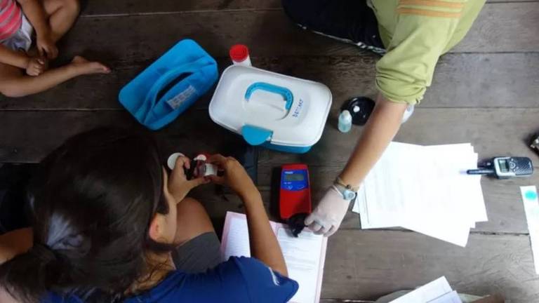 A pesquisadora Patrícia Torres coleta uma amostra de sangue de uma das crianças entre 6 meses e 5 anos analisadas no estudo, no Amazonas